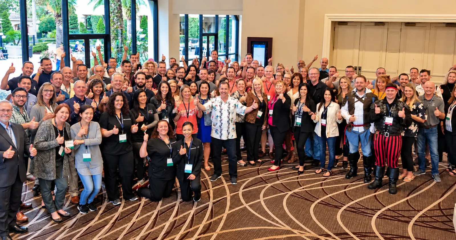 Seminar attendees with Dr. Mark Sanna giving a thumbs-up in a hotel foyer