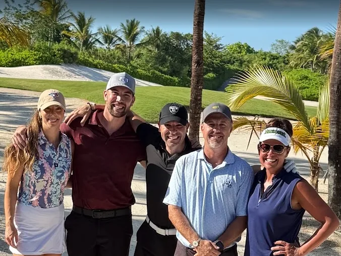 Dr. Mark Sanna with four others on a tropical golf course
