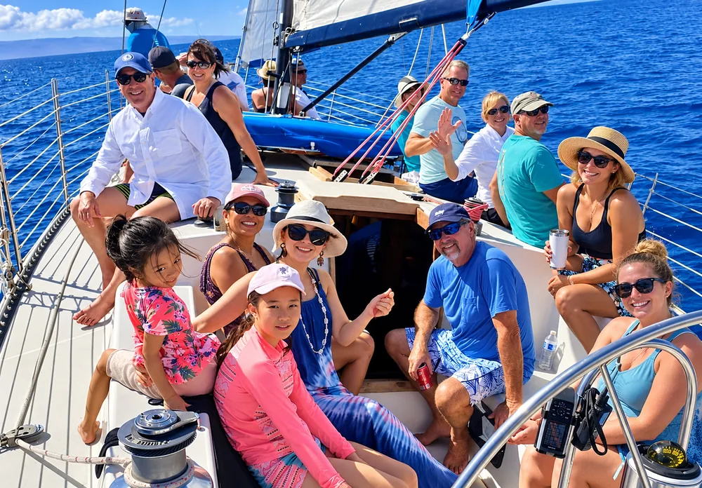 A group of adults and children sailing on open blue water