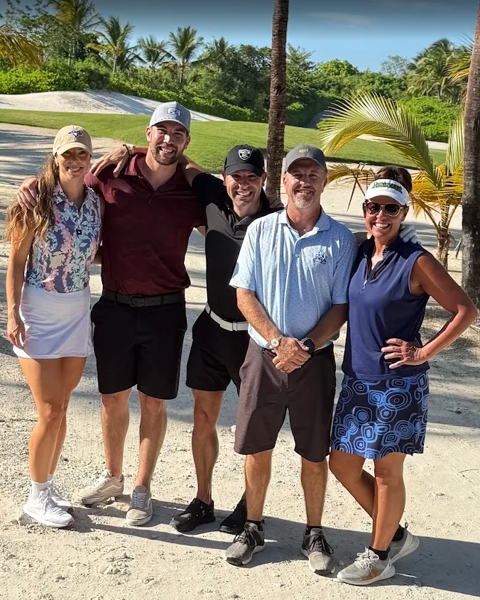 Dr. Mark Sanna with four others on a tropical golf course