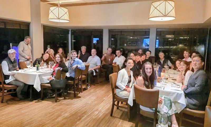 Retreat attendees gathered around dinner tables in a restaurant