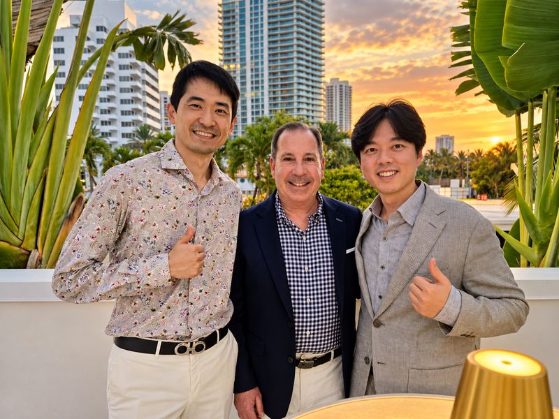 Dr. Mark Sanna with two attendees on an outdoor terrace in Miami Beach